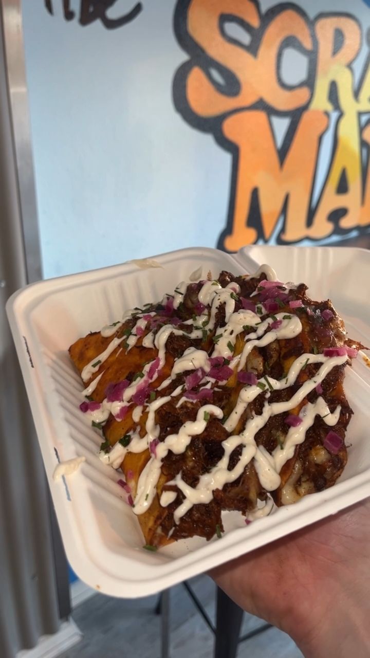 Loaded street food topped with sauce and pickled onion