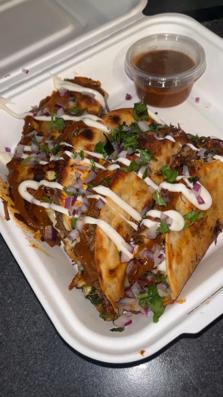 Tacos topped with sauce, red onion and coriander