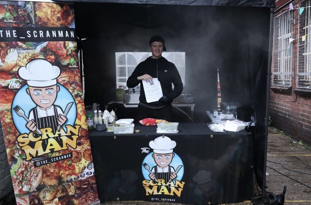 The Scran Man market stall with the logo banner and table cover